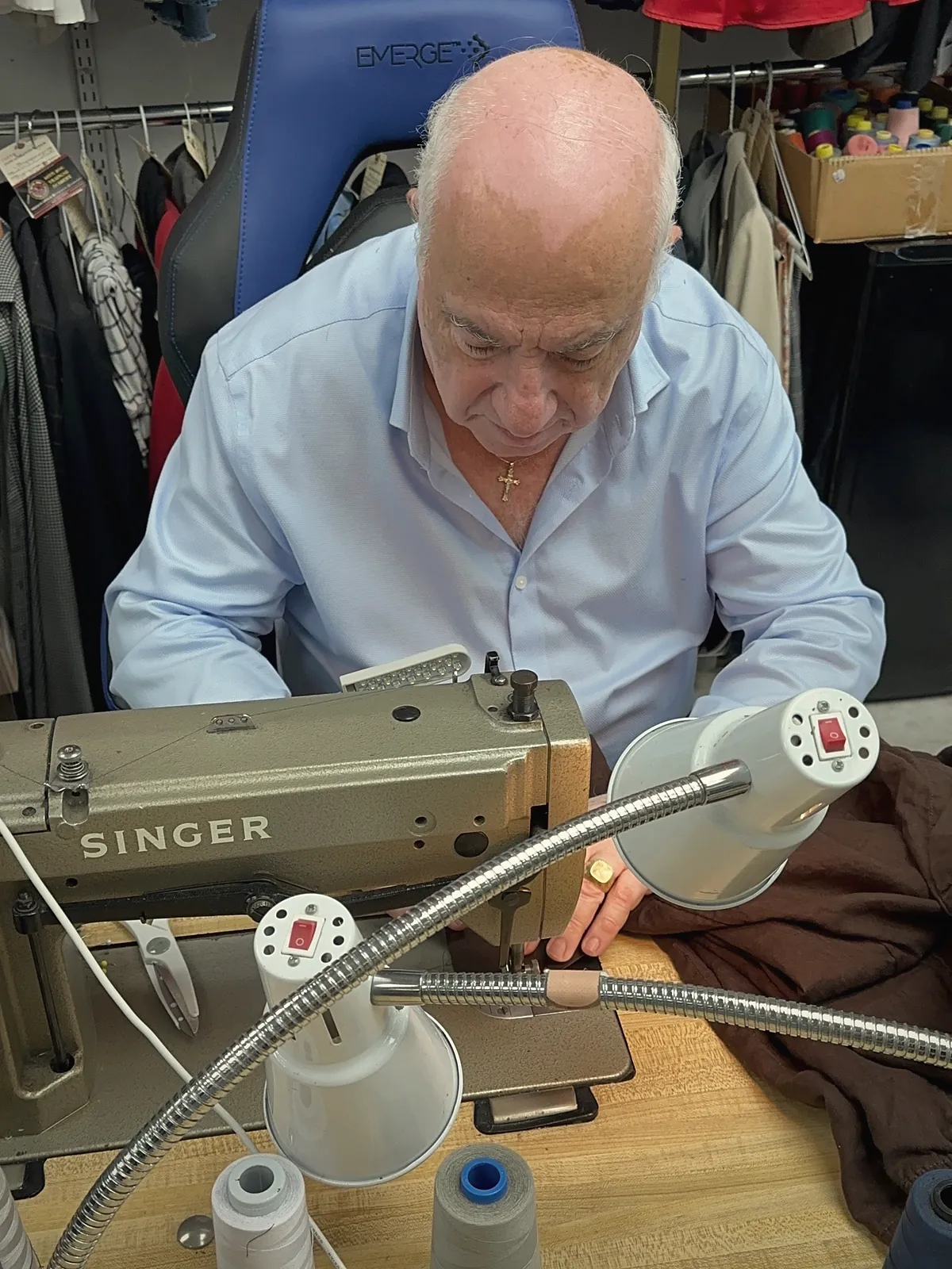 Sami Abujudeh sewing at his Singer machine in the shop